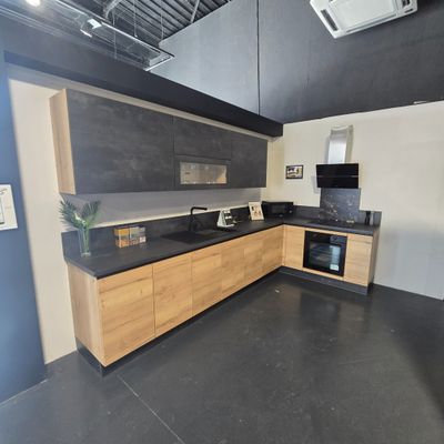 a kitchen with a black counter top and wooden cabinets