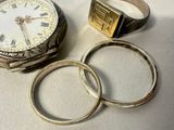 two rings and a watch sitting on a table