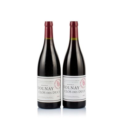 two bottles of red wine sitting next to each other on a white surface
