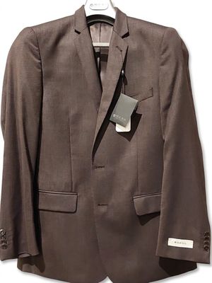 the jacket is brown and has a tag on it