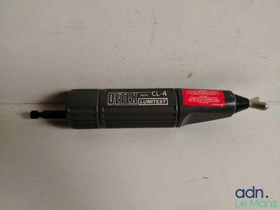 un gros plan d'un stylo noir et rouge posé sur une surface blanche