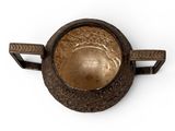 a small metal bowl with a handle on a white surface