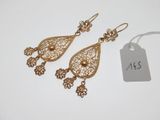 une paire de boucles d'oreilles dorées ornées de détails en filigrane