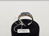 un gros plan d'une bague exposée dans une vitrine, accompagnée d'une étiquette
