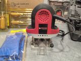 a red and black electric sander on a table