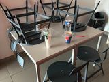 une table et des chaises dans une pièce où une télévision est accrochée au mur