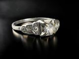 a close up of a diamond ring on a black surface