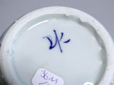 a blue and white vase with a tag on it