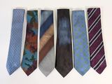 several different colored ties are arranged in a row on a white surface