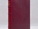 a red book sitting on top of a white surface