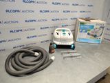 une photo représentant un aspirateur et un tuyau posés sur une table