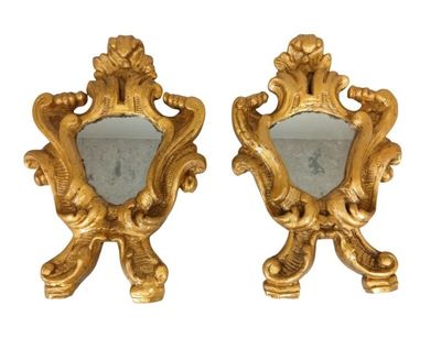 une paire de miroirs dorés avec un cadre doré et un miroir orné d'un oiseau