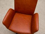 an image of a brown leather chair sitting on top of a cement floor