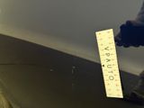 a man standing next to a ruler on the ground