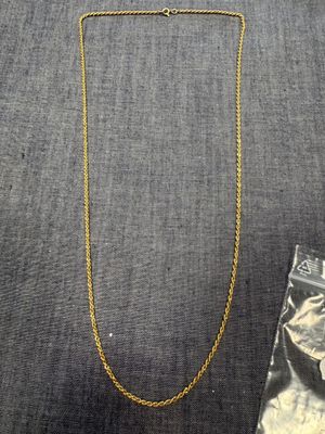 un collier en or et un sac rempli de bijoux posés sur une table