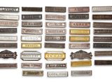 many different types of metal nameplates on a white surface
