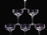 six verres à vin sont empilés les uns sur les autres sur un fond noir