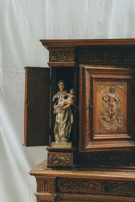 une armoire en bois surmontée d'une statue