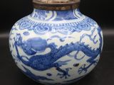 a blue and white vase sitting on a black surface