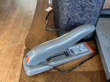 a stapler on a table next to a laptop