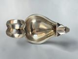 an image of a silver spoon and spoon rest on a white surface