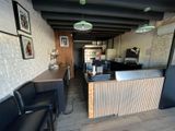 une pièce avec un comptoir, des chaises et des tableaux accrochés au mur