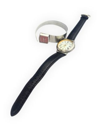 a watch and a ring on a white surface