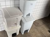two trash cans sitting next to each other on the floor