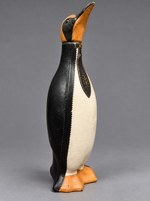 une figurine de pingouin en noir et blanc sur fond gris