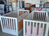 deux lits bébé qui se trouvent dans une pièce où il y a beaucoup d'affaires