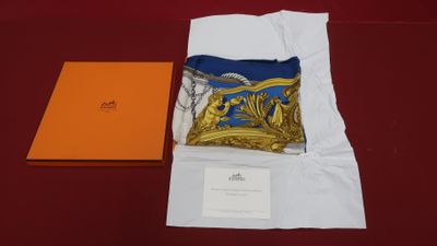 an orange box with a blue scarf and a gold pillow on a red table