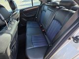 the back seats of a silver car with black leather trims