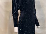 the mannequin is wearing a black dress with polka dots on it