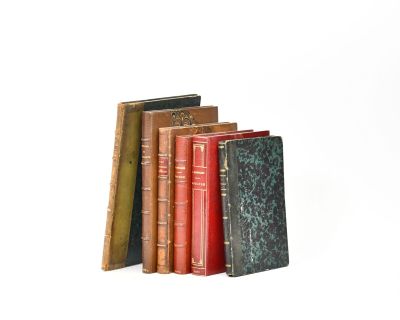 several books are stacked on top of each other on a white surface