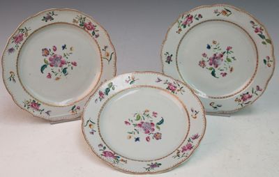 three plates with flowers on them sitting on a table