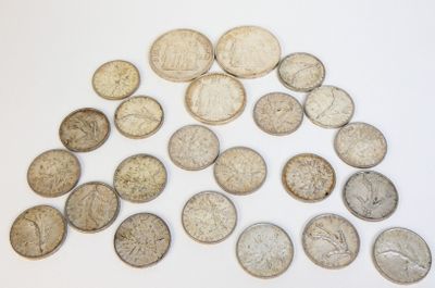 une pile de vieilles pièces d'argent sur une surface blanche