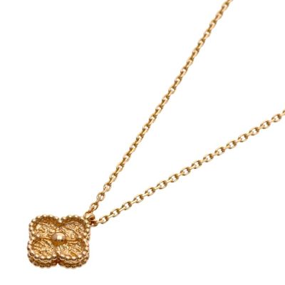 a close up of a gold necklace with a knot on a chain