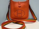 an orange purse with a yellow and red ribbon around it