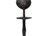 a black sculpture of a woman ' s face on a stand