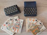 plusieurs cartes à jouer et une boîte posées sur une table en bois