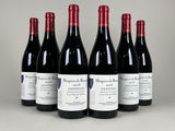 six bouteilles de vin rouge sont alignées sur une table
