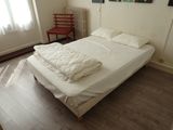 a bed with a white comforter on it in a room