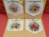 four cross stitch kits with sunflowers on them sitting on a bed