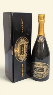 une image représentant une bouteille de champagne posée à côté d'une boîte