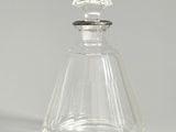 clear glass perfume bottle with a silver lid and a diamond shaped top