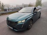 La voiture verte est garée sur le bord de la route, dans le brouillard.