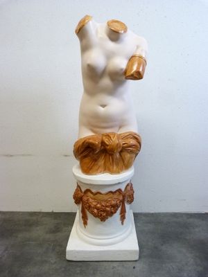 une statue représentant une femme assise sur un pot