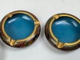 two blue bowls with gold rims on a white surface