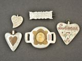 quatre bijoux en argent et en or posés sur un fond gris