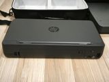 a black hp printer sitting on a table next to a black case
